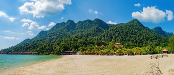 Relaxing on remote paradise beach Tropical bungalow and luxury house on untouched sandy beach with palms trees in Langkawi Island Malaysia