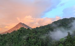 Sunset by Arenal Volcano in Costa Rica cloud forest clouds rise from the jungle floor