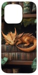 Coque pour iPhone 15 Pro Petit dragon endormi sur une bibliothèque