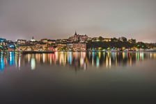 Stockholm city lights and night view of Sodermalm district buildings reflected in the water Evening Stockholm cityscape with illumination Riddarfjarden marina and Soder Malarstrand embankment