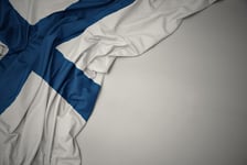 Waving national flag of finland on a gray background