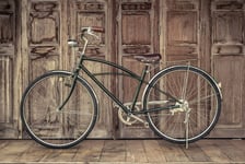 Vintage bicycle on vintage wooden house vintage tone Thai style vintage wooden door not Wood stain the door made of Teak wood Tectona grandis is Auspicious Tree in Thailand