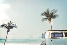 Vintage car parked on the tropical beach seaside with a surfboard on the roof - Leisure trip in the summer