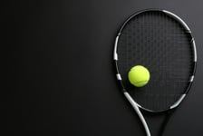 Tennis racket and ball on black background