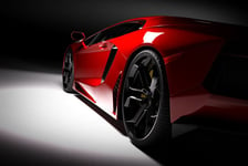 Red fast sports car in spotlight black background Shiny new luxurious