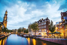 The most famous canals and embankments of Amsterdam city during sunset General view of the cityscape and traditional Netherlands architecture